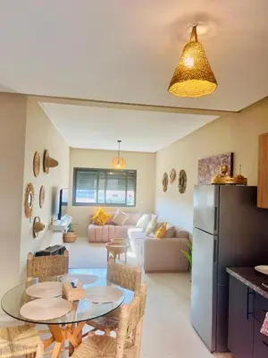 a kitchen and living room with a table and a refrigerator at Nice Apartment near airport mohammed V International Casablanca in Deroua
