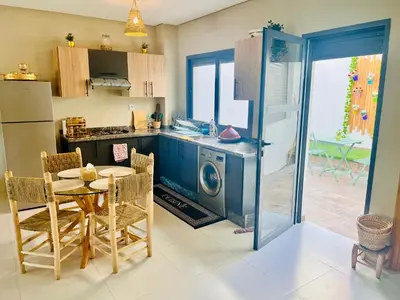 a kitchen with a table and a washing machine at Nice Apartment near airport mohammed V International Casablanca in Deroua