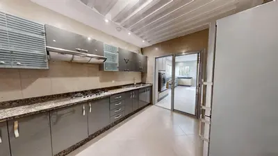 a large kitchen with stainless steel cabinets and a glass door at Villa F- Luxury 4 suites on a 5000sqm in the heart of Ambassadeurs in Rabat