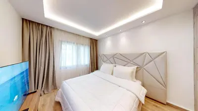a bedroom with a large bed and a television at Villa F- Luxury 4 suites on a 5000sqm in the heart of Ambassadeurs in Rabat