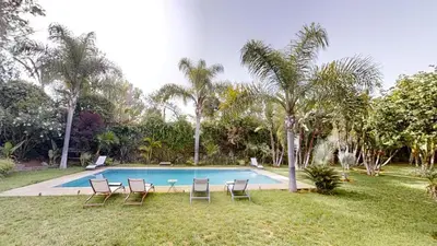 a swimming pool with four chairs and a table at Villa F- Luxury 4 suites on a 5000sqm in the heart of Ambassadeurs in Rabat