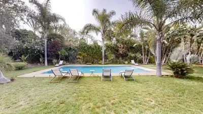 a group of chairs sitting next to a swimming pool at Villa F- Luxury 4 suites on a 5000sqm in the heart of Ambassadeurs in Rabat