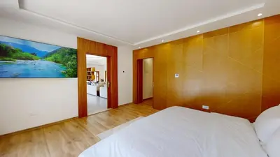 a bedroom with a white bed and a painting on the wall at Villa F- Luxury 4 suites on a 5000sqm in the heart of Ambassadeurs in Rabat