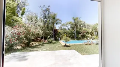 an external view of a backyard with a swimming pool at Villa F- Luxury 4 suites on a 5000sqm in the heart of Ambassadeurs in Rabat