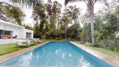 a swimming pool in the backyard of a house at Villa F- Luxury 4 suites on a 5000sqm in the heart of Ambassadeurs in Rabat