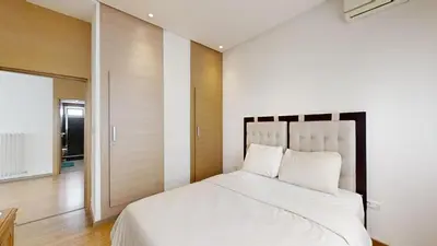 a bedroom with a large white bed with a wooden headboard at Villa 44- Superbe Villa Moderne 7 chambres, 2500m2, piscine, cinema, clim , meublee in Rabat