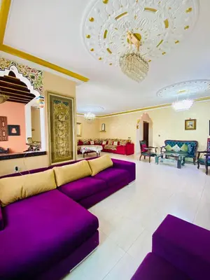 a living room with purple couches and a chandelier at harhoura Résidence Badia in Temara
