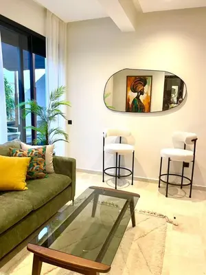 a living room with a couch and a table and two stools at Casablanca Maarif Extension Green Retreat in Casablanca