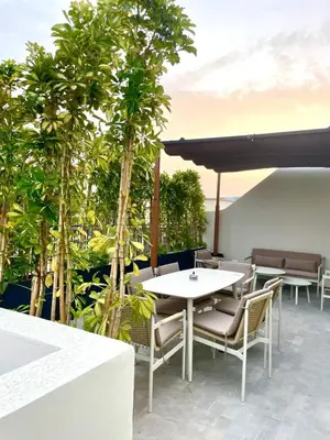 a table and chairs on a patio with trees at Casablanca Maarif Extension Green Retreat in Casablanca
