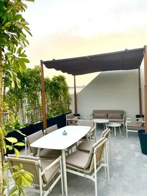 a patio with tables and chairs under a canopy at Casablanca Maarif Extension Green Retreat in Casablanca