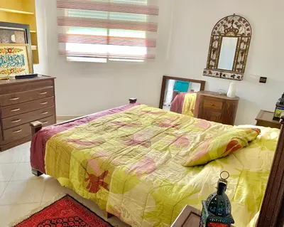 a bedroom with a bed and a dresser and a mirror at Paradis Avec Piscine et Vue sur mer Harhoura in Temara