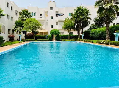 a large blue swimming pool in front of a building at Paradis Avec Piscine et Vue sur mer Harhoura in Temara