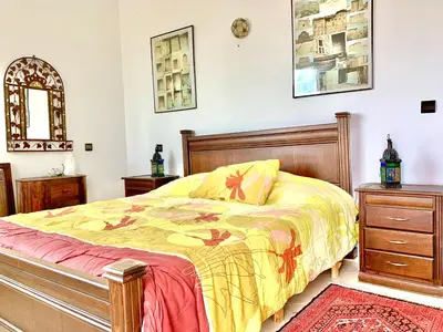 a bedroom with a bed with a yellow comforter at Paradis Avec Piscine et Vue sur mer Harhoura in Temara