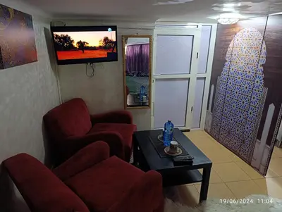 a living room with two chairs and a table and a tv at Alone Studio in Casablanca
