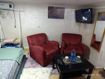 a room with two chairs and a table and a tv at Alone Studio in Casablanca