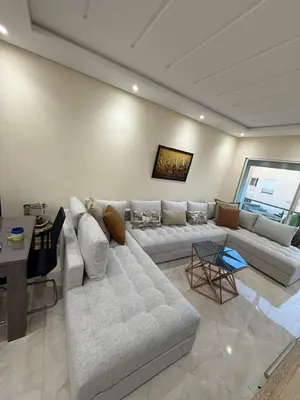 a living room with a couch and a table at Logement paisible in Bouznika