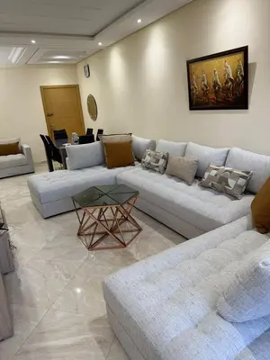 a living room with a couch and a table at Logement paisible in Bouznika