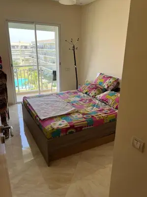 a bedroom with a bed and a window at Logement paisible in Bouznika