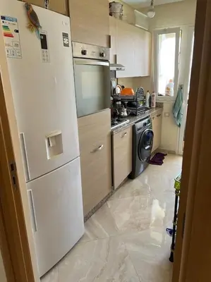 a kitchen with a white refrigerator and a dishwasher at Logement paisible in Bouznika