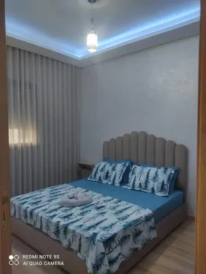 a bedroom with a bed with a blue comforter at Ocean Park Zenata City Eco in Casablanca