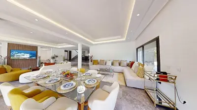 a living room with a table and couches at Villa S- Luxurious 8 masterbedrooms villa on 3000m2, close to all amenities, Golf and heart of Souissi in Rabat