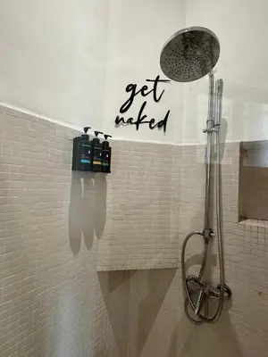 a shower in a bathroom with a sign on the wall at Loft art-déco centre-ville Casa in Casablanca