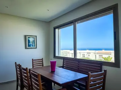 a dining room table with a view of the ocean at Villa de luxe résidence front de mer 50m de la mer in Tamaris
