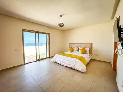 a bedroom with a bed with a view of the ocean at Villa de luxe résidence front de mer 50m de la mer in Tamaris