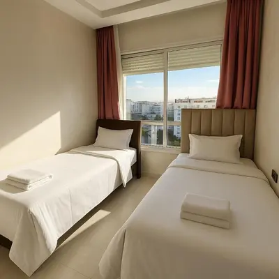 two beds in a room with a window at Cosy ensoleillé 3 CH - central et proche du train et tramway in Casablanca