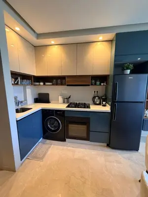 a kitchen with blue cabinets and a refrigerator at Studio Iris CFC in Casablanca