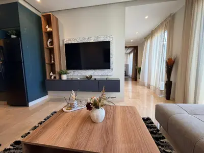 a living room with a tv and a table at Studio Iris CFC in Casablanca