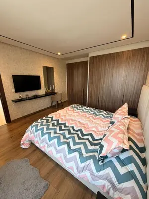 a bedroom with a large bed and a television at Studio Iris CFC in Casablanca