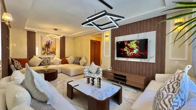 a living room with a couch and a tv at N30 Élégance et Confort à La Corniche Rabat - Appartement de Luxe Essabah in Rabat