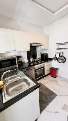 a kitchen with a stainless steel sink and white cabinets at N30 Élégance et Confort à La Corniche Rabat - Appartement de Luxe Essabah in Rabat