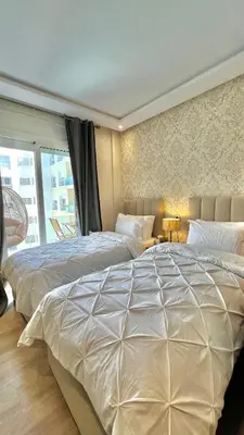 a bedroom with two beds and a window at N30 Élégance et Confort à La Corniche Rabat - Appartement de Luxe Essabah in Rabat
