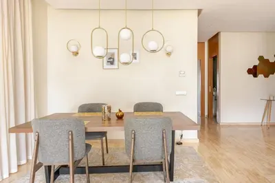 a dining room with a wooden table and chairs at Sojori CFC fibre et parking in Casablanca