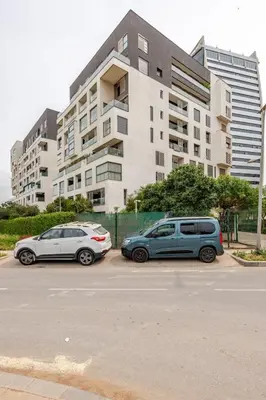 two cars parked in a parking lot in front of a building at Sojori CFC fibre et parking in Casablanca