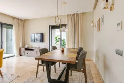 a dining room with a wooden table and chairs at Sojori CFC fibre et parking in Casablanca