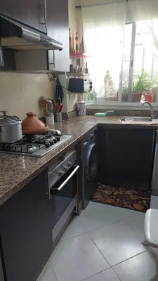 a kitchen with a stove and a washing machine at Sweet home in Dar Bouazza