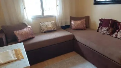 a couch with pillows on it in a living room at Sweet home in Dar Bouazza