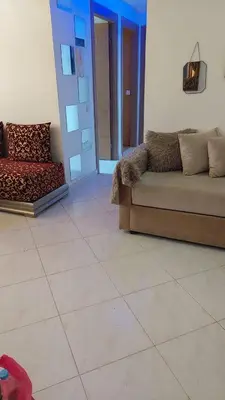 a living room with a couch and a tile floor at Sweet home in Dar Bouazza