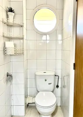 a bathroom with a white toilet and a window at Appartement en résidence privée in Casablanca