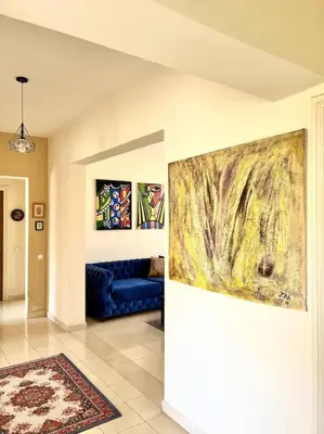 a living room with a blue couch and a painting on the wall at Appartement en résidence privée in Casablanca
