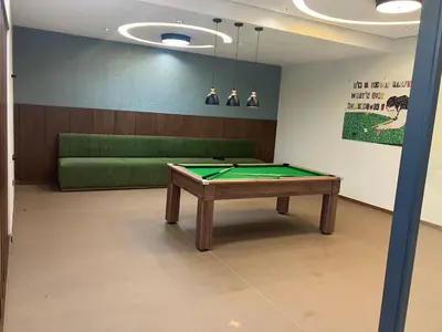 a room with a pool table and a green couch at Moroccan Beach Delight in Dar Bouazza