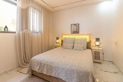 a white bedroom with a bed and a window at Charm and Calm - Superbe appartement de luxe - Dahomy Beach - Bahia Beach in Bouznika