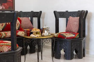 a table with a tea kettle and two chairs at Charm and Calm - Superbe appartement de luxe - Dahomy Beach - Bahia Beach in Bouznika