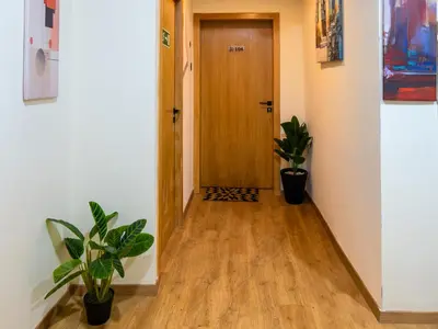 a hallway with a wooden door and two potted plants at Unico Hotel Maarif in Casablanca