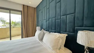 a bedroom with a blue headboard and a bed with pillows at Garden View and Terrace 3BR - AppartAli Luxury Platform in Casablanca