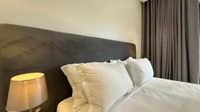 a bedroom with a bed with white pillows and a lamp at Garden View and Terrace 3BR - AppartAli Luxury Platform in Casablanca