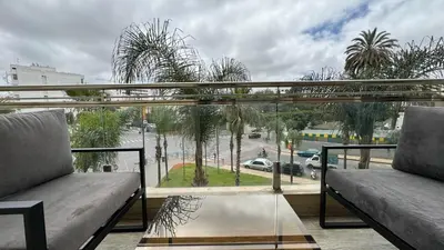 a balcony with a view of a street with palm trees at Garden View and Terrace 3BR - AppartAli Luxury Platform in Casablanca